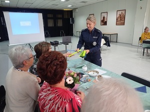 Policjantka przekazuje Seniorom odblaski