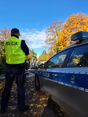 policjant stoi przy radiowozie