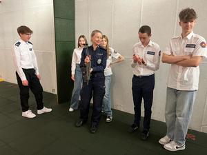Policjant pokazuje uczniom, jak obchodzić się z bronią