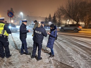 policjanci z innymi służbami rozdają odblaski na dworcu