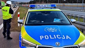 Funkcjonariusz ruchu drogowego wykonujący statyczny pomiar prędkości.