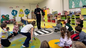 Na zdjęciu widzimy policjantkę, która tłumaczy jak prawidłowo korzystać z przejść dla pieszych.