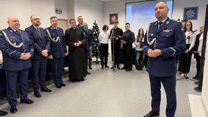 Na zdjęciu znajdują się policjanci, goście oraz pracownicy cywilni w trakcie spotkania wigilijnego w Komendzie Miejskiej Policji w Toruniu