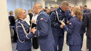 Na zdjęciu znajdują się policjanci, goście oraz pracownicy cywilni w trakcie spotkania wigilijnego w Komendzie Miejskiej Policji w Toruniu