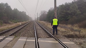 Na zdjęciach widać umundurowanego policjanta oraz funkcjonariusza Straży Ochrony Kolei na dworcu kolejowym Toruń Dworzec Główny. Policjant posiada założoną odblaskową kamizelkę koloru jaskrawo-żółtego z napisem "POLICJA". Na kolejnych zdjęciach policjant znajduje się w rejonie torów.