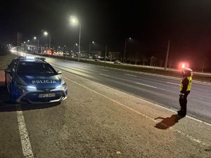 Policjanci Wydziału Ruchu drogowego kontrolujący porządek na drodze. Pora nocna.