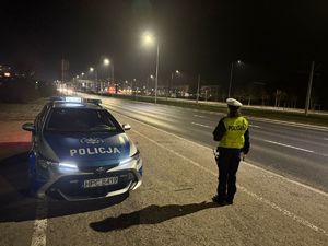 Policjanci Wydziału Ruchu drogowego kontrolujący porządek na drodze. Pora nocna.