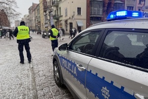 Na zdjęciach widzimy policjantów oraz wolontariuszy WOŚP.  Zdjęcia wykonane są na toruńskiej starówce oraz w Dowrze Artusa. Na zdjęciach widać policyjne radiowozy, umundurowanych policjantów.