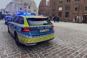 Na zdjęciach widzimy policjantów oraz wolontariuszy WOŚP.  Zdjęcia wykonane są na toruńskiej starówce oraz w Dowrze Artusa. Na zdjęciach widać policyjne radiowozy, umundurowanych policjantów.