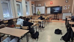 Na zdjęciu są profilaktycy na zajęciach z uczniami, podczas których omawiają tematykę bezpiecznych ferii, hejtu, przemocy rówieśniczej oraz narkotyków.