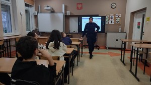 Na zdjęciu są profilaktycy na zajęciach z uczniami, podczas których omawiają tematykę bezpiecznych ferii, hejtu, przemocy rówieśniczej oraz narkotyków.