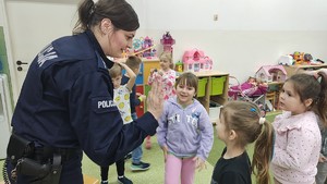 Na zdjęciach znajduje się policjantka oraz pracownik Zespołu ds. Profilaktyki Społecznej podczas spotkania z dziećmi przedszkola.