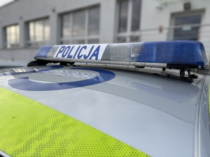 Zdjęcie górnej części radiowozu. Widać belkę świateł pojazdu uprzywilejowanego i napis POLICJA