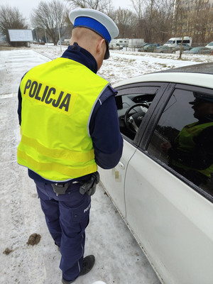 na zdjęciach widzimy umundurowanego policjanta ruchu drogowego. Mundurowy dokonuje kontroli kierujących pojazdami osobowymi.