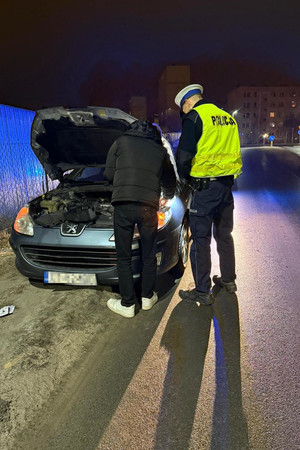 Na zdjęciach widać pojazd osobowy oraz umundurowanego policjanta wydziału ruchu drogowego. Policjant stoi przy przodzie auta z otwartą przednią pokrywą silnika. Na kolejnym zdjęciu policjant pomaga w usunięciu pojazdu z drogi.