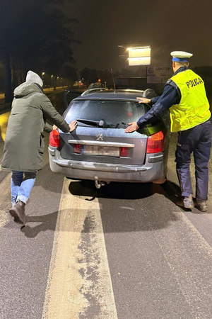 Na zdjęciach widać pojazd osobowy oraz umundurowanego policjanta wydziału ruchu drogowego. Policjant stoi przy przodzie auta z otwartą przednią pokrywą silnika. Na kolejnym zdjęciu policjant pomaga w usunięciu pojazdu z drogi.