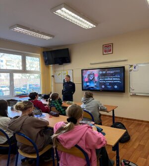 Na zdjęciu widać umundurowaną policjantkę trackie zajęć z młodzieżą szkolną.