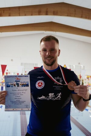 Na zdjęciach widzimy mł. asp. Piotra Wiśniewskiego - policjanta Komisariatu Policji w Chełmży. Mundurowy zajął 3 miejsce w nocnym maratonie pływackim. Na ostatnim zdjęciu widnieje dyplom wraz z medalem.