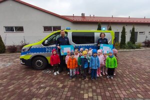 Na zdjęciach widać dzieci z przedszkola oraz policjantów w trackie profilaktycznego spotkania.