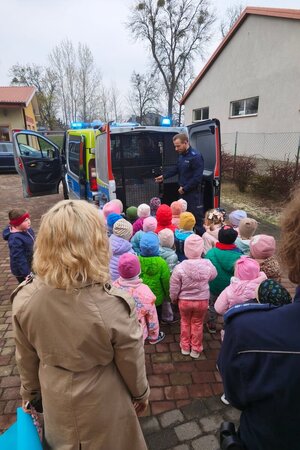 Na zdjęciach widać dzieci z przedszkola oraz policjantów w trackie profilaktycznego spotkania.