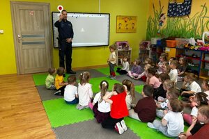 Na zdjęciach widać dzieci z przedszkola oraz policjantów w trackie profilaktycznego spotkania.
