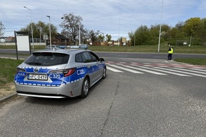Na zdjęciu widać policyjny radiowóz oraz umundurowanego policjanta realizującego czynności służbowe.