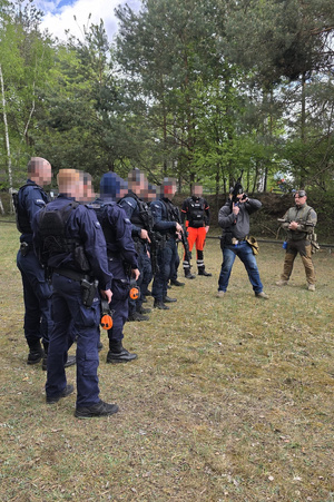Na zdjęciach widać umundurowanych policjantów z toruńskiej Grupy Szybkiego Reagowania oraz policyjnych wywiadowców. Twarze zostały zamazane. Funkcjonariusze biorą udział w szkoleniu na otwartej strzelnicy.