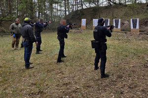 Na zdjęciach widać umundurowanych policjantów z toruńskiej Grupy Szybkiego Reagowania oraz policyjnych wywiadowców. Twarze zostały zamazane. Funkcjonariusze biorą udział w szkoleniu na otwartej strzelnicy.