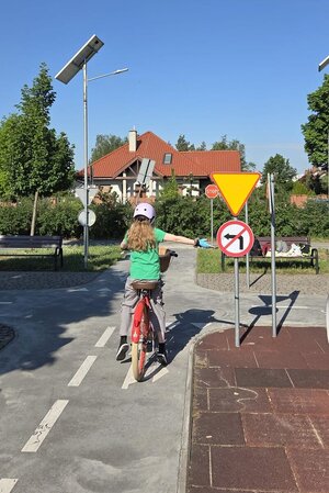 Na zdjęciach znajdują się uczniowie podchodzący do egzaminu na kartę rowerową. Na fotografiach widać także umundurowaną policjantkę ruchu drogowego.