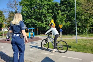 Na zdjęciach znajdują się uczniowie podchodzący do egzaminu na kartę rowerową. Na fotografiach widać także umundurowaną policjantkę ruchu drogowego.