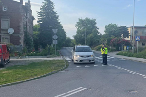 Na zdjęciu widać dwóch umundurowanych policjantów Oddziału Prewencji Policji wykonujących kontrole stanu trzeźwości kierujących pojazdami.