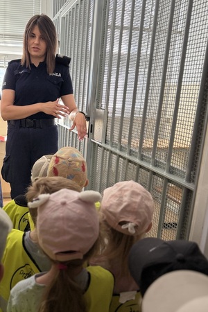 Zdjęcia przedstawiają dzieci w trakcie zwiedzania Komisariatu Policji na toruńskim Śródmieściu. Widać na nich umundurowanych policjantów.