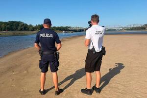 Na zdjęciach widać umundurowanych funkcjonariusza Policji oraz Strażnika Miejskiego. Kontrolują rzekę Wisłę.