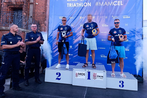 Na zdjęciach znajduje się policjant, zajmujący 3 miejsce na podium w zawodach triathlonowych. Kolejne zdjęcie to wygenerowane z aplikacji czasy w których pokonał dystans jazdy na rowerze, biegania oraz pływania.
