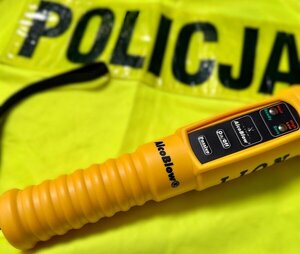 zdjęcie urządzenia do badania stanu trzeźwości oraz kamizelki odblaskowej z napisem POLICJA
