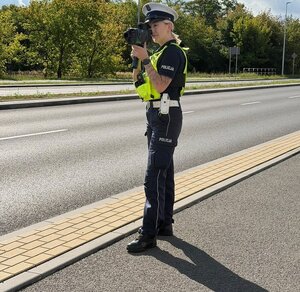 na zdjęciu widać umundurowanych policjantów w trakcie wykonywania czynności służbowych.