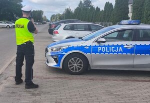na zdjęciu widać umundurowanych policjantów w trakcie wykonywania czynności służbowych.