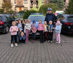 na zdjęciach znajduje się umundurowany policjant ruchu drogowego wraz z maluchami na zajęciach.